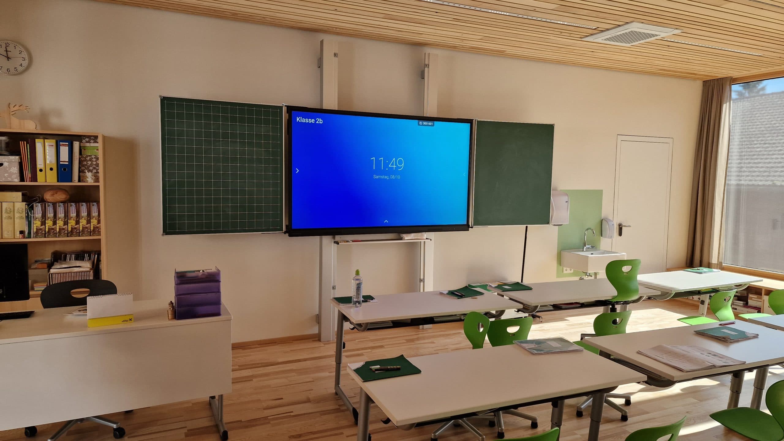 Interaktives Clevertouch-Multitouch-Display in einem Klassenzimmer der Volksschule Breitenbach mit geöffneten Seitenflügeln.